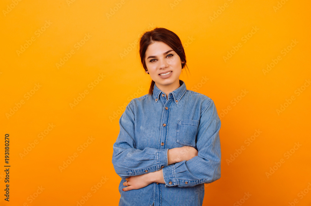 Portrait of cheerful smiling young woman with crossed arms over orange background. Portrait of cheerful smiling young woman with crossed arms over orange background.