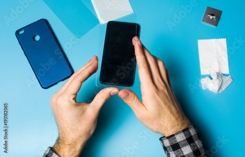 фотографія Man applying protective tempered glass to phone screen