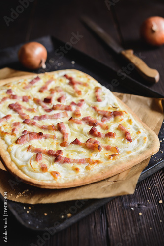 Traditional Tarte flambée with crème fraiche, cheese, onion and bacon