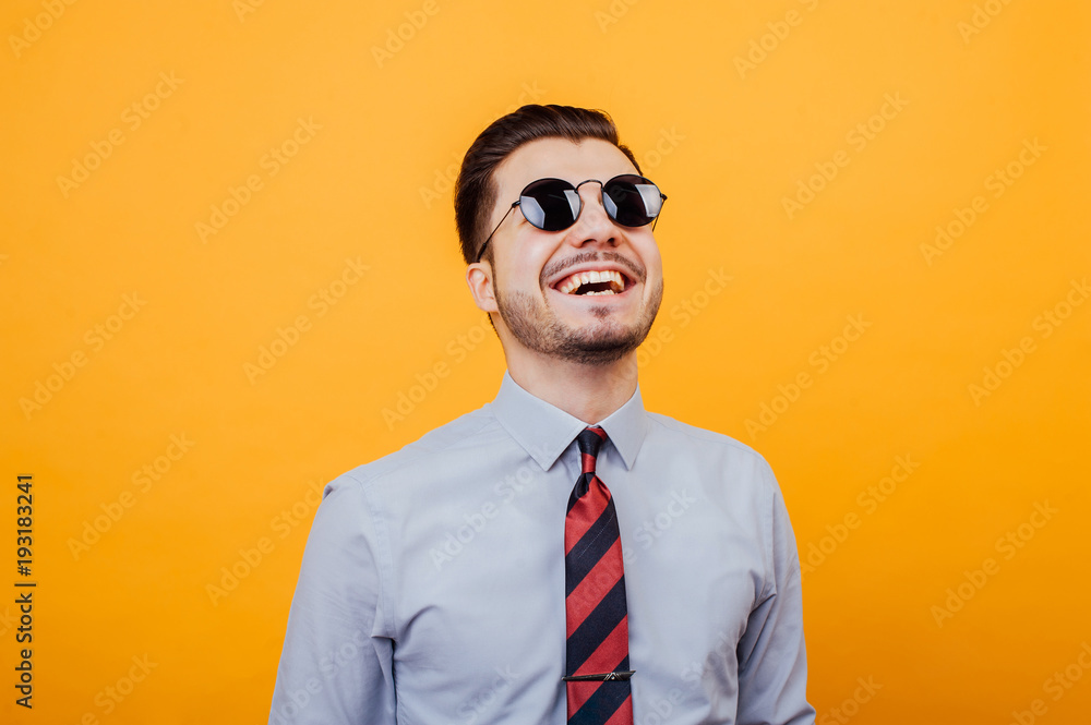Happy smiling young man with sunglasses over yellow background. Happy smiling young man with sunglasses over yellow background.