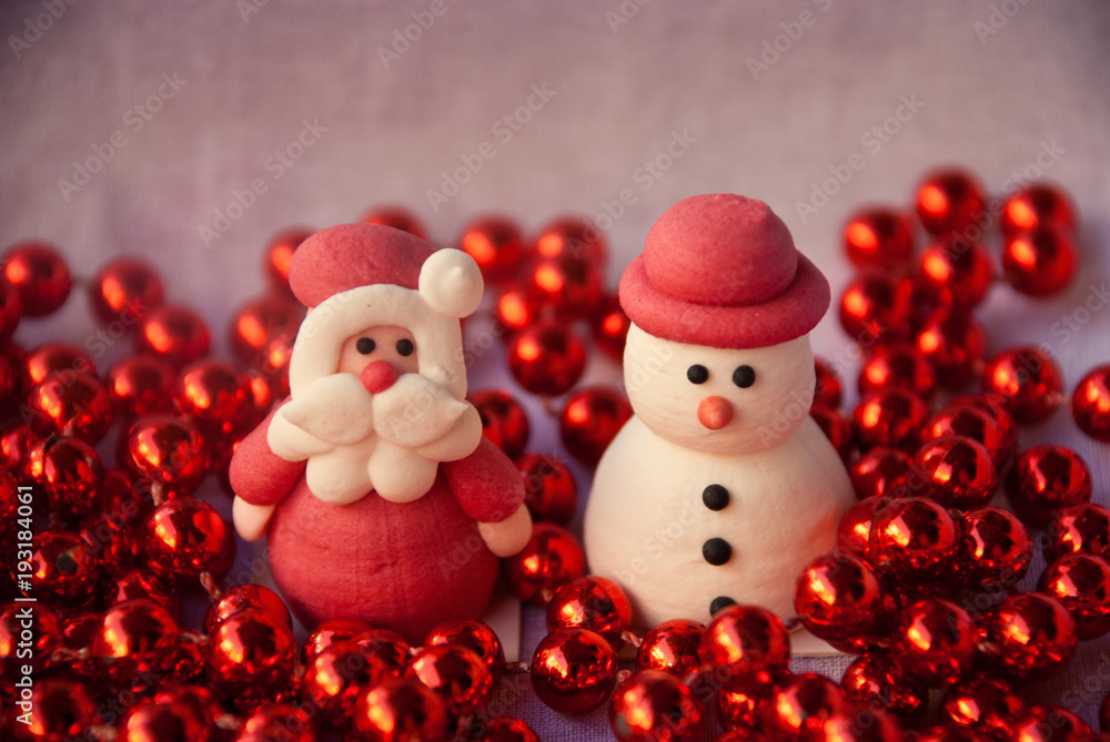 Figures of Santa Claus and Snowman with red garland. New year card. Merry christmas background. Xmas postcard. Figures of Santa Claus and Snowman with red garland. New year card. Merry christmas background. Xmas postcard.