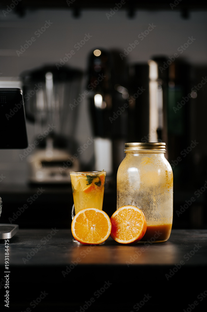Preparation of lemonade from orange, lemon, lime and mint in a glass bottle in a restaurant kitchen Preparation of lemonade from orange, lemon, lime and mint in a glass bottle in a restaurant kitchen