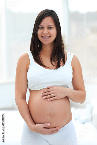 portrait of young pregnant woman on a light background. Free Download portrait of young pregnant woman on a light background. - GFXLoad