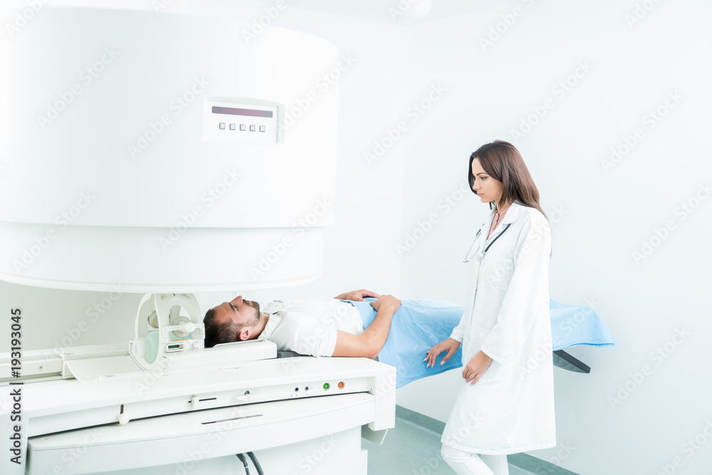 Obraz premium Male Patient In Hospital Bed, getting visited by female doctor to do checkup.