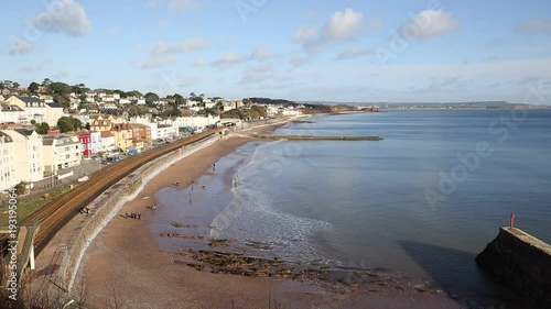Dawlish Devon train appraoching in English coast town with beach railway train and sea