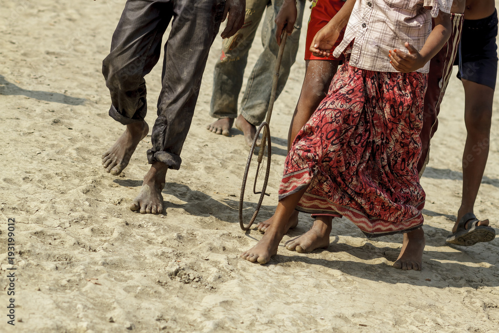 Sundarbans / Bangladesh - November 2012: Children play while adults work on rice fields in Bangladesh.