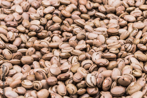 Beans of Carioca beans scattered across the table / Feijão Carioca