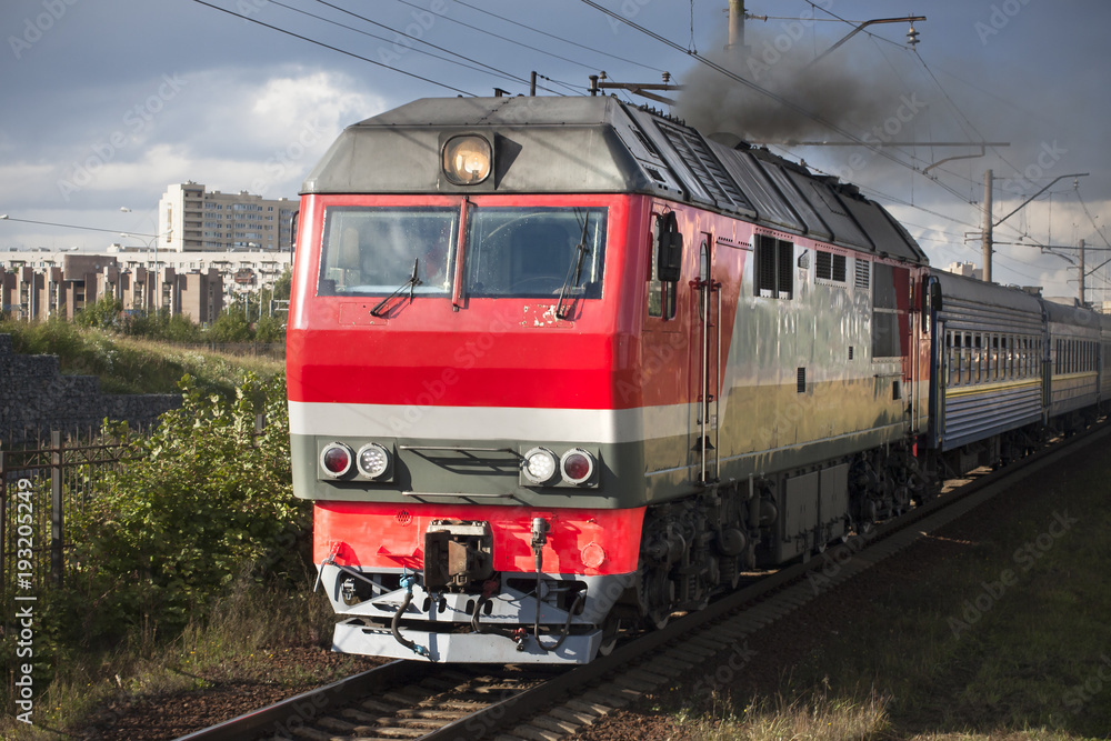 Heavy locomotive on railway in the city close up.