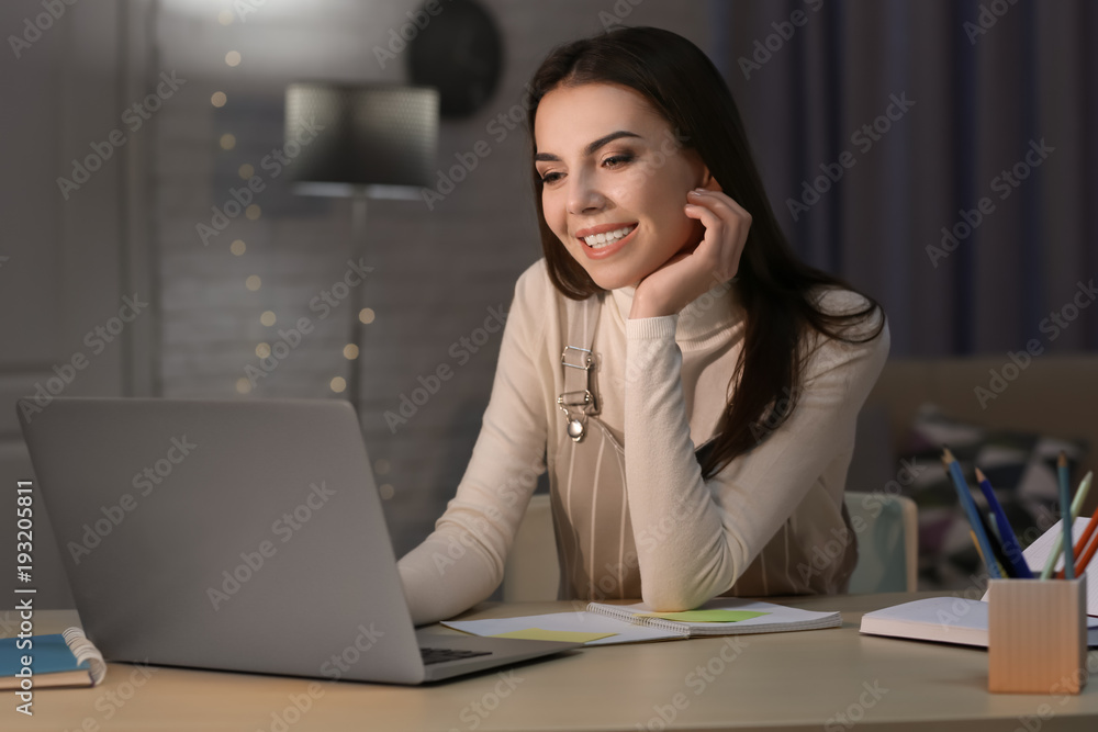 Young woman working late in home office