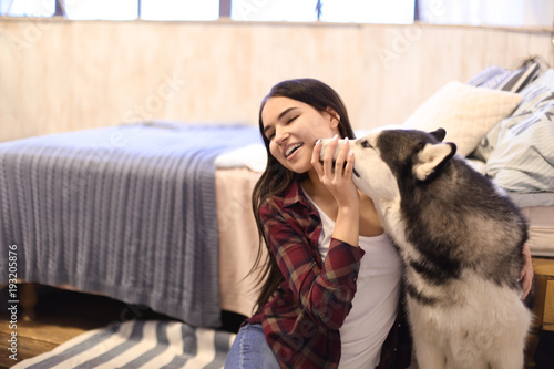 Young woman with cute Husky dog at home. Pet adoption