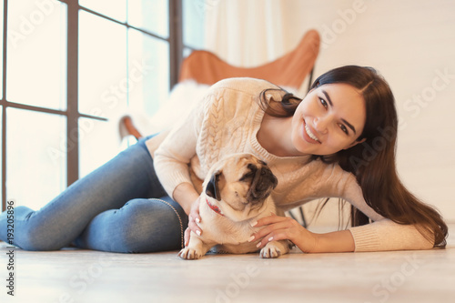 Young woman with cute pug d...