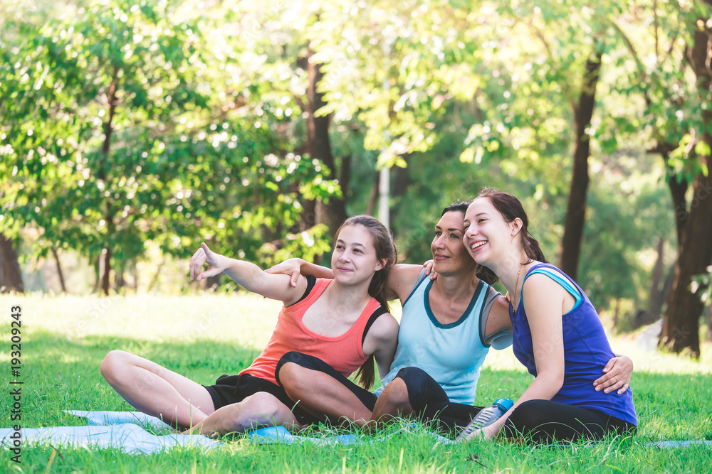 Activities in the family, mother and daughter relaxing in the park after practicing yoga. Activities in the family, mother and daughter relaxing in the park after practicing yoga.