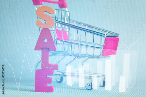 Double exposure of Sale text and shopping cart trolley on blue background with financial graph, shopping discount and merketing concept. photo