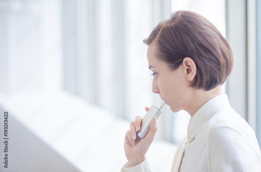加熱式タバコを吸うショートヘアーの女性 Stock 写真 Adobe Stock
