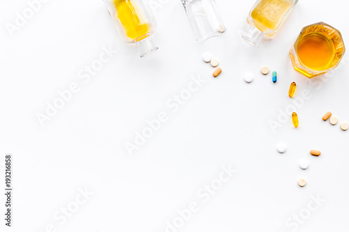 Alocohol abuse and alcoholism treatment concept. Glasses, bottles and medcine pills on white background top view copy space photo