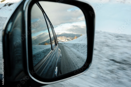 View on the mountains in car mirror