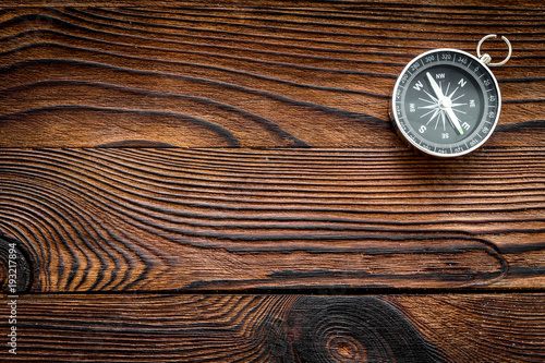 Compass on dark wooden background top view copy space