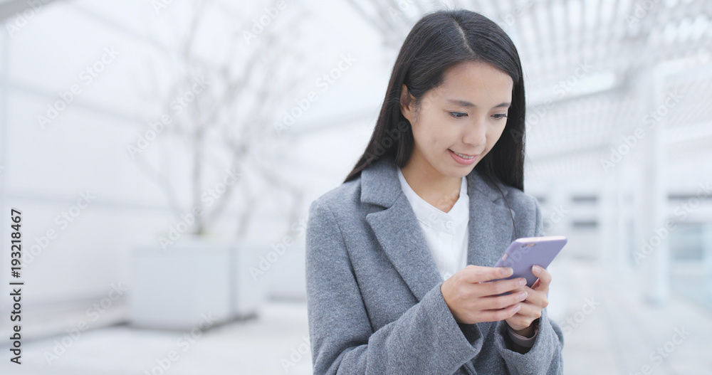 Businesswoman sending sms on cellphone at outdoor Businesswoman sending sms on cellphone at outdoor