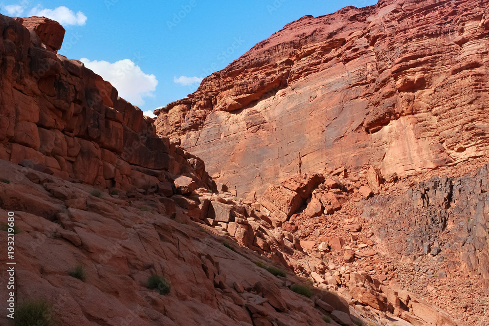 Red stone walls of the canyon of Wadi Rum desert in Jordan. Wadi Rum also known as The Valley of the Moon is a valley cut into the sandstone and granite rock in southern Jordan to the east of Aqaba. Red stone walls of the canyon of Wadi Rum desert in Jordan. Wadi Rum also known as The Valley of the Moon is a valley cut into the sandstone and granite rock in southern Jordan to the east of Aqaba.