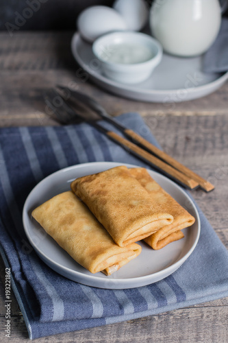 Russian Puncake Crepes stuffed with mushrooms and mozzarella on wooden table background.