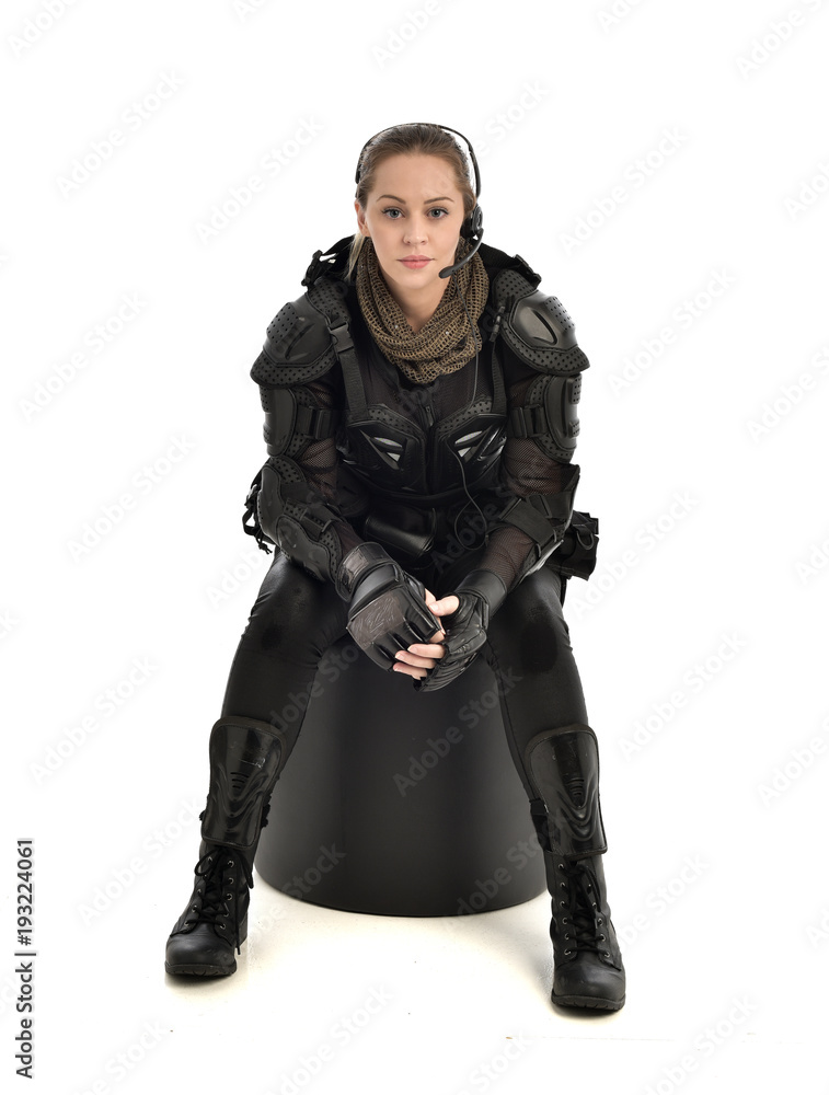 full length portrait of female wearing black tactical armour, crouching pose, isolated on white studio background. full length portrait of female wearing black tactical armour, crouching pose, isolated on white studio background.