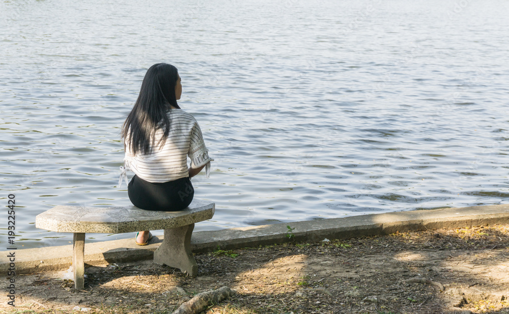Asian woman on a chair sitting alone at the river., Bridge and Lake  background. with copy space for text., lonely concept. sad concept. relax  concept. Stock Photo | Adobe Stock