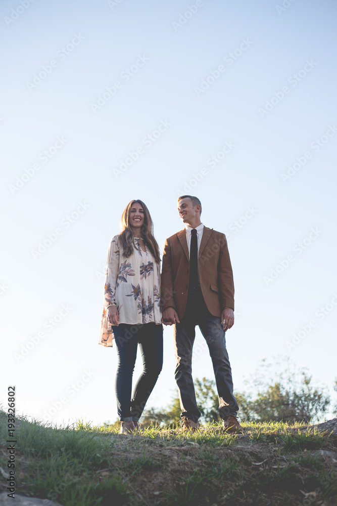 Man and a Woman stanidng in a field with the camera angled up Man and a Woman stanidng in a field with the camera angled up