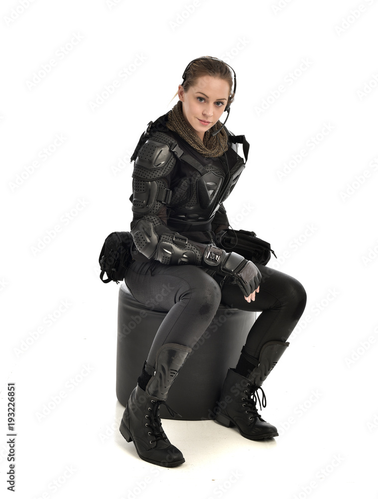full length portrait of female wearing black tactical armour, crouching pose, isolated on white studio background. full length portrait of female wearing black tactical armour, crouching pose, isolated on white studio background.
