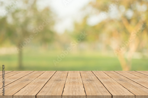 Empty wood table top on nature green blurred background at garden,space for montage show products