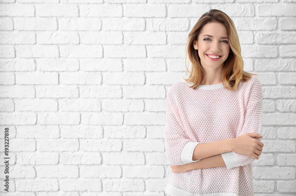 Portrait of beautiful smiling woman on brick wall background Portrait of beautiful smiling woman on brick wall background