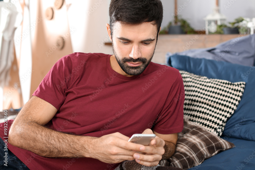 Young man using mobile phone indoors Young man using mobile phone indoors