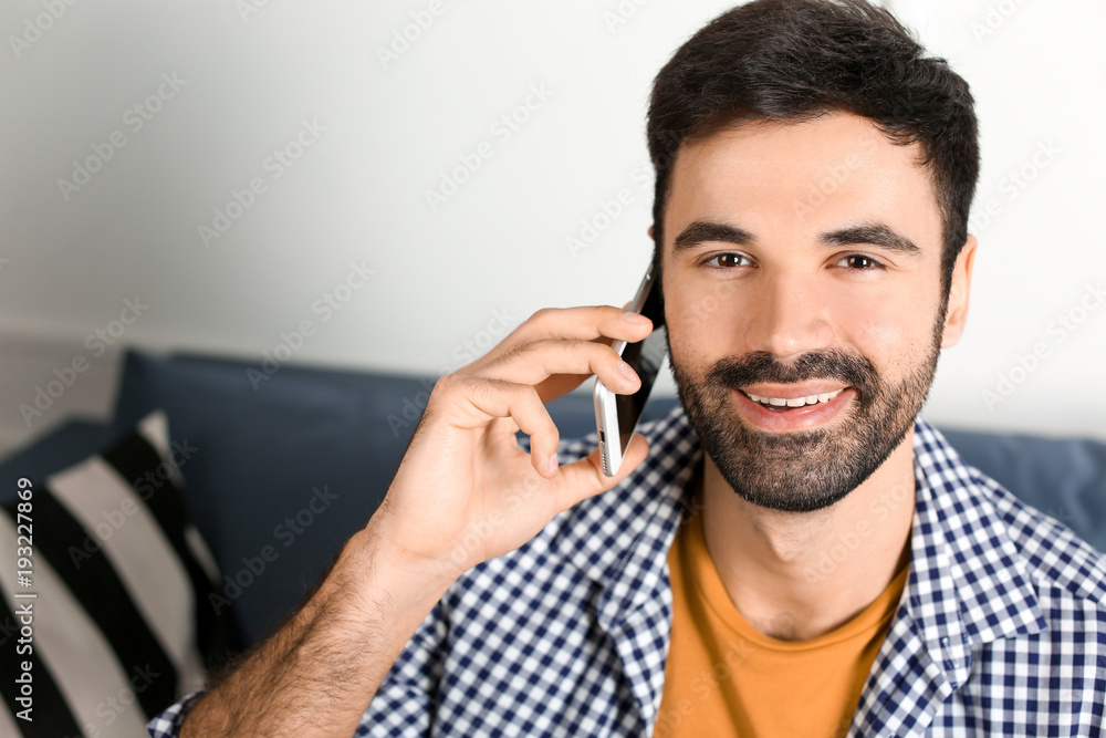 Young man talking on mobile phone indoors Young man talking on mobile phone indoors