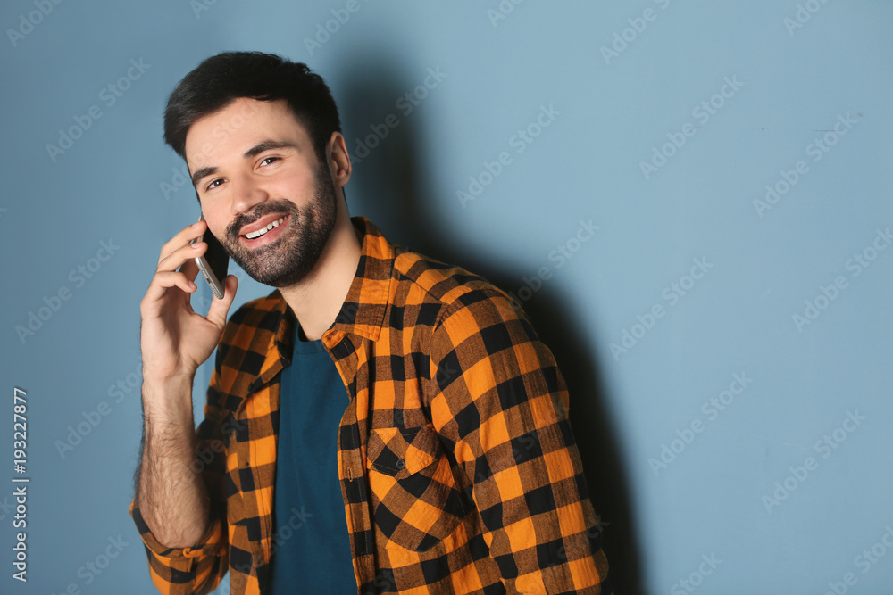 Young man talking on mobile phone against color background Young man talking on mobile phone against color background