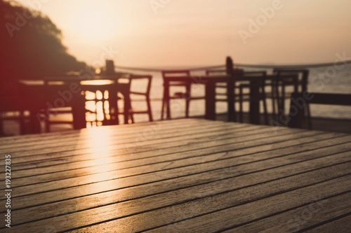 Empty wood table top and blurred restaurant summer beach with sea and sunset background. - can used for display or montage your products.