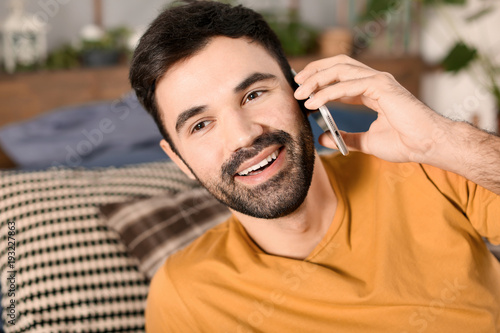 Young man talking on mobile phone indoors