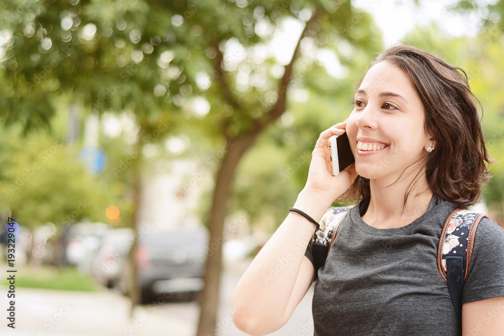 Portrait of young woman talking with her smartphone. Portrait of young woman talking with her smartphone.