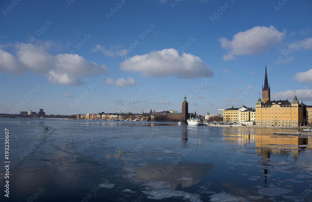 Fototapeta premium A snowy, cold and sunny view of Riddarholmen and the Town City Hall, The Knights' Islet, Stockholm
