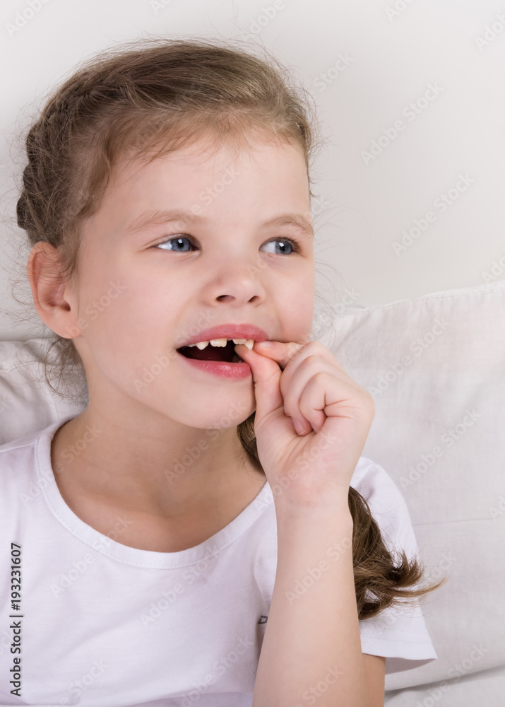 beautiful girl woke up in bed and touches her new tooth beautiful girl woke up in bed and touches her new tooth