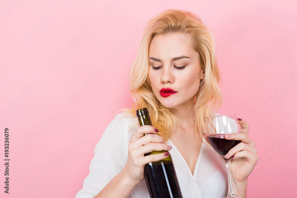 Blonde woman holding wine bottle and glass Blonde woman holding wine bottle and glass