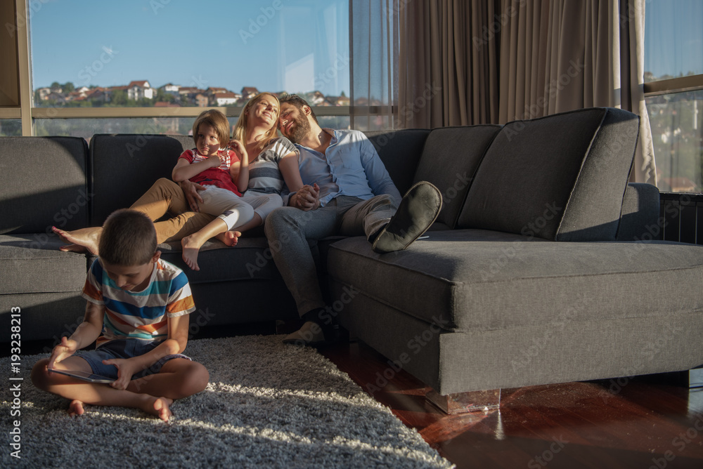 Obraz premium happy young couple spending time with kids at home