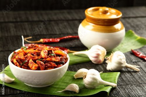 Traditional Indian achar picked garlic served with fermenting pickle jar  photo