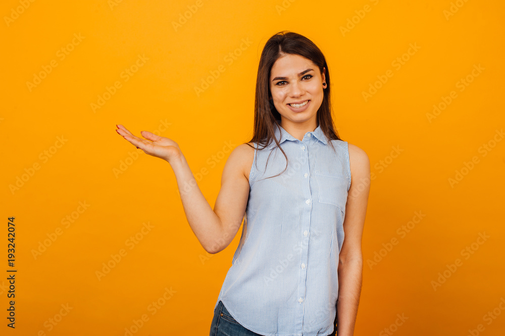 Portrait of a happy smiling woman holding copyspace on the palm isolated on a orange background Portrait of a happy smiling woman holding copyspace on the palm isolated on a orange background