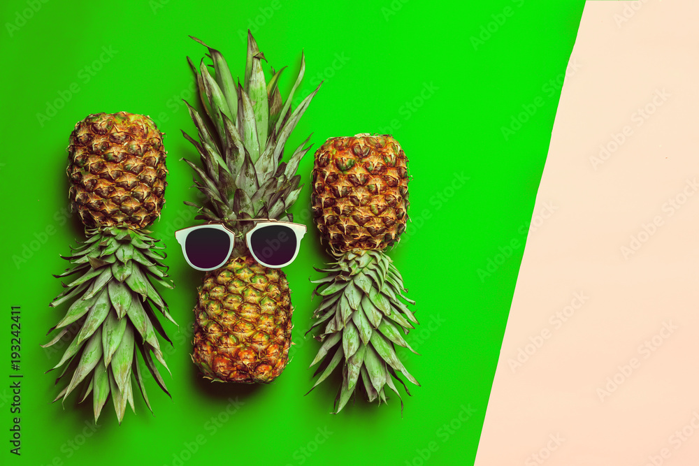 Fototapeta premium pineapple on colored paper with glasses