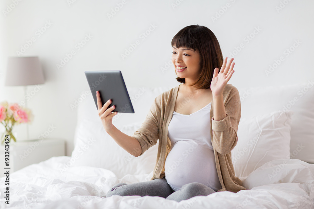 happy pregnant asian woman with tablet pc at home happy pregnant asian woman with tablet pc at home