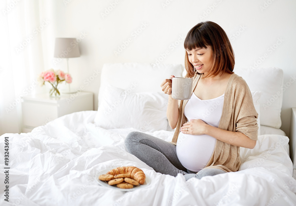 happy pregnant woman with cup drinking tea at home happy pregnant woman with cup drinking tea at home