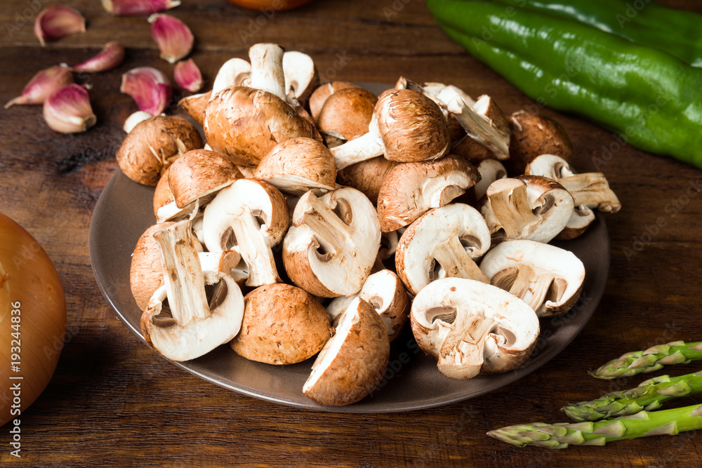 Fototapeta premium cut raw mushrooms and other ingredients on rustic wood