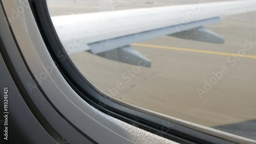 View from porthole of the plane to the runway. The plane is preparing for takeoff photo