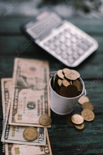 Fotografía Calculator with money and pennies on a wooden green background