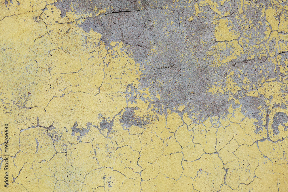 Obraz premium An old yellow paint on a concrete wall.