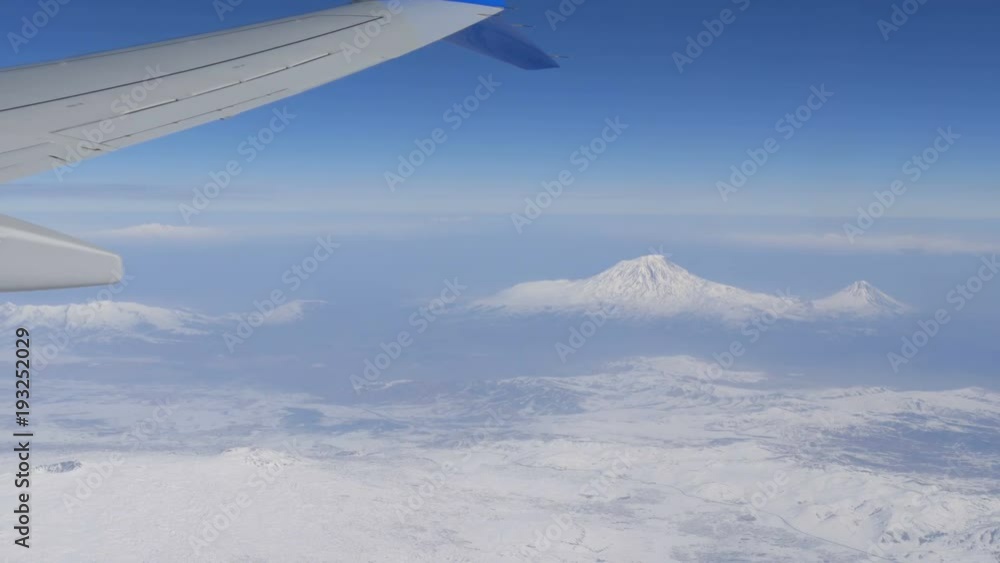 View of Mount Ararat from an airplane. The wing of the plane and snow-capped mountain top. Biblical mount Ararat taken from Airplane View of Mount Ararat from an airplane. The wing of the plane and snow-capped mountain top. Biblical mount Ararat taken from Airplane